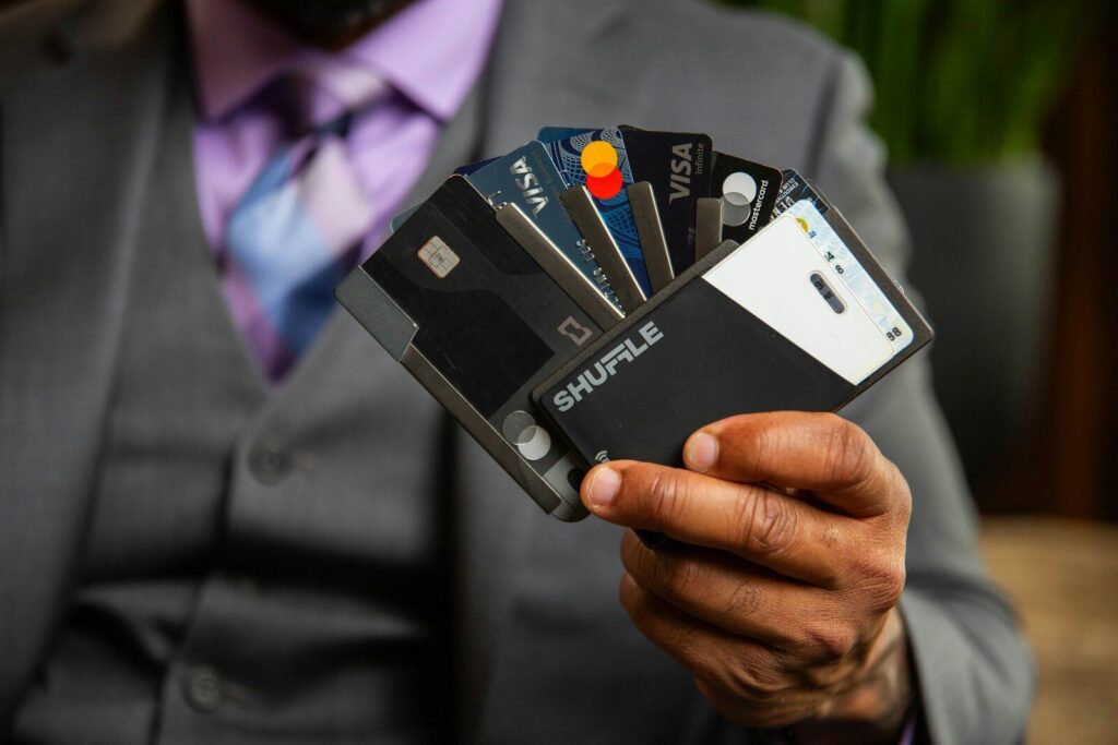a man in a suit holding four credit cards